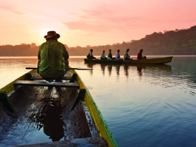 Turistas disfrutan un paseo en canoa durante un amanecer tranquilo-laguna chalalán
